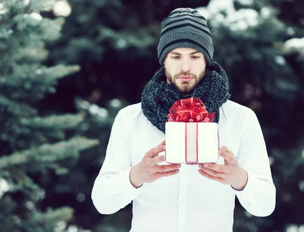 Handsome man with present box in winter outdoor — Stock Photo, Image