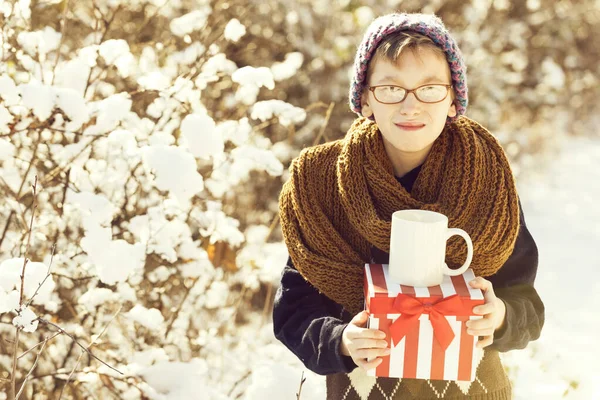 Niño pequeño con regalo y copa en invierno al aire libre —  Fotos de Stock