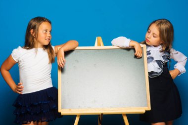 Mavi arka planda okul üniformalı kızlar