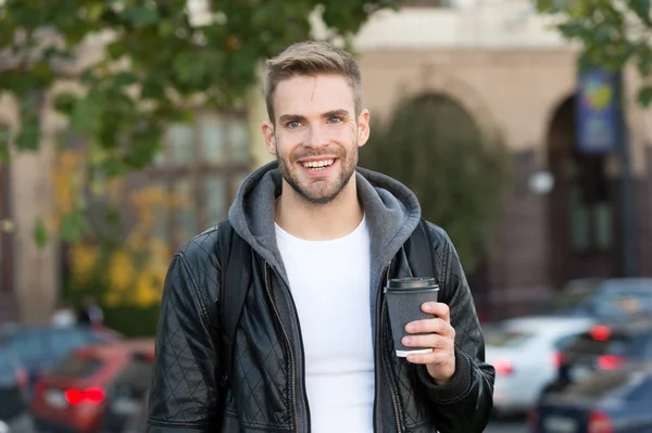 Šťastné ráno. Hipster drží papírový šálek kávy. Pauza na kafe. Vypij to na cestu. Muž usmívající se veselý hipster držet kávu vzít pryč. Student pije kávu venku. Rituály určují charakter — Stock fotografie