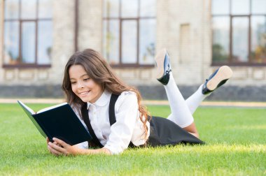 Read every day. Cute small child read library book on green grass. Adorable little girl learning to read at leisure. Reading as hobby. I read everywhere clipart