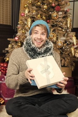 Hediye kutusu ile mutlu adam oturup Noel ağacı