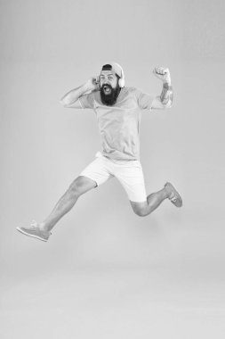 Ritim enerjisi. Müzik hayranı. Adam hareket halinde müzik kablosuz kulaklık lar dinleyin. Sakallı adam müzikten hoşlanır. Aceleci hareket. Hipster dans atlama kulaklık gadget. İlham verici bir şarkı. Müzik kütüphanesi