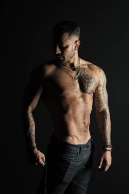 Fitness ve spor ile ilgilenmek. Dövmeli kol ve göğüs olan adam. Güçlü gövde sakallı adam. Seksi göbek ile dövme modeli. Sporcu ya da atlet moda kot pantolon