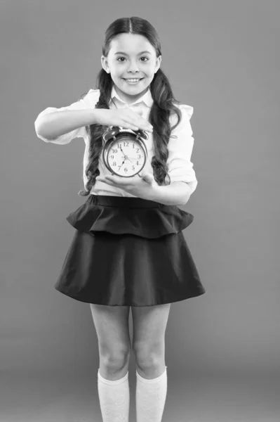 Classes begin. Developing discipline. Time for break and relax. Vacation time. Elementary school day bell schedule. Schooltime concept. Schoolgirl child formal uniform hold alarm clock. Time to study — Stock Photo, Image