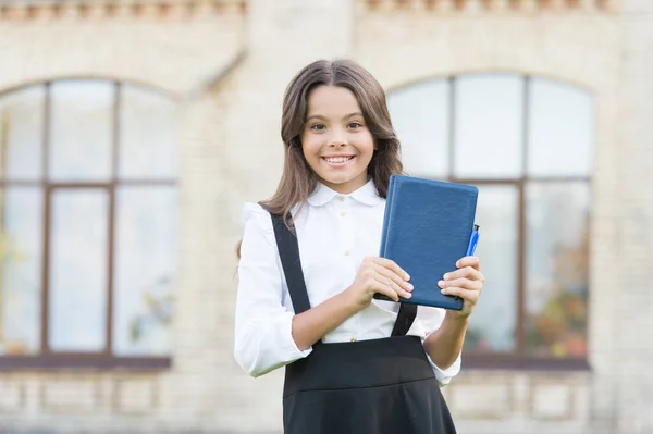 Met bibliotheek bent u vrij. Happy small child hold bibliotheek boek met blauwe omslag. Schattig klein meisje leent boeken in de schoolbibliotheek. Bibliotheek en bibliopole. Boeken en informatie. Kennisdag — Stockfoto