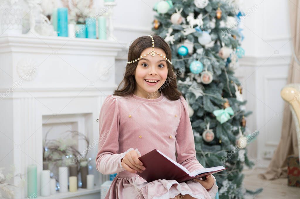 New year eve. Little girl reading Christmas story. Magic atmosphere. Christmas spirit. Little reader enjoy reading at home. Best Christmas book. Books shop commercial. Little smiling child read book