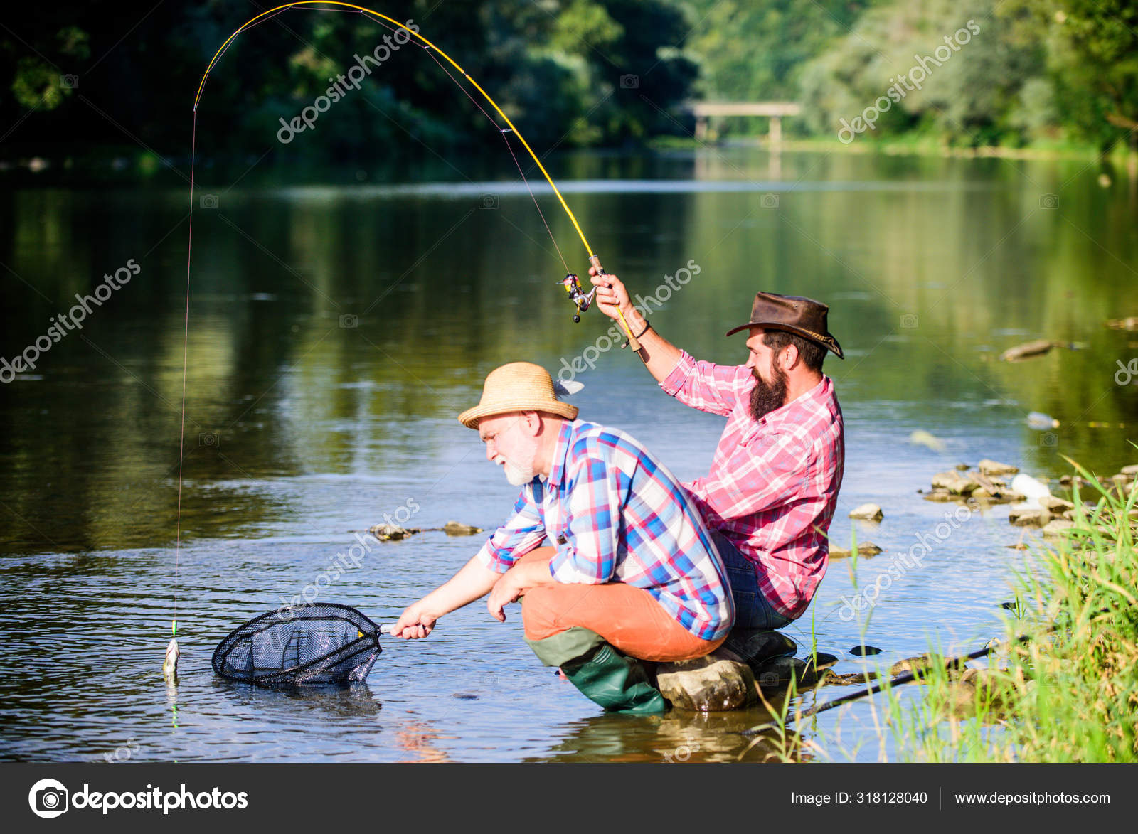 Hunting. happy fishermen friendship. Catching and fishing. Two male friends  fishing together. retired dad and mature bearded son. fly fish hobby of men  in checkered shirt. retirement fishery Stock Photo by ©stetsik