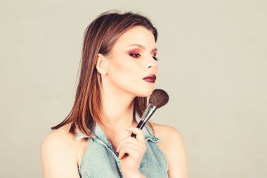 İyi görünmek ve kendinden emin hissetmek. Cilt bakım kozmetikleri. Makyaj fırçası uygulayan çekici kadın. Profesyonel makyaj malzemeleri. Makyaj sanatçısı kavramı. Kadınlığı vurgulayın. Kız göz farı uygulamak