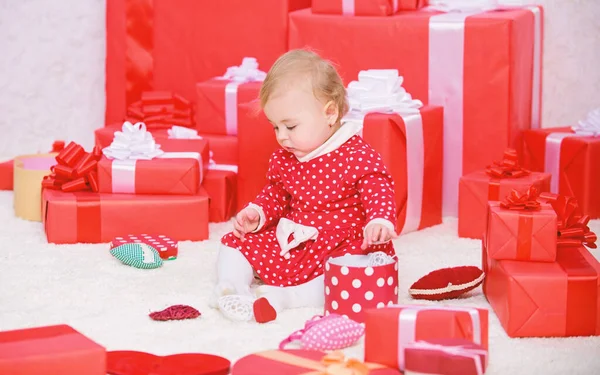 Немовля перше Різдво в житті. Подарунки для дитини перше Різдво. Маленька дитина грає біля купи загорнутих червоних подарункових коробок. Моє перше Різдво. Ділитися радістю з дитиною перше Різдво з сім'єю — стокове фото