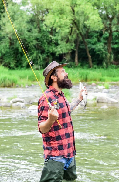 Fishing masculine hobby. Fishing requires you to be mindful and fully present in moment. Fisher fishing equipment. Fish on hook. Brutal man wear rubber boots stand in river water. Weekend activity — Stock Photo, Image