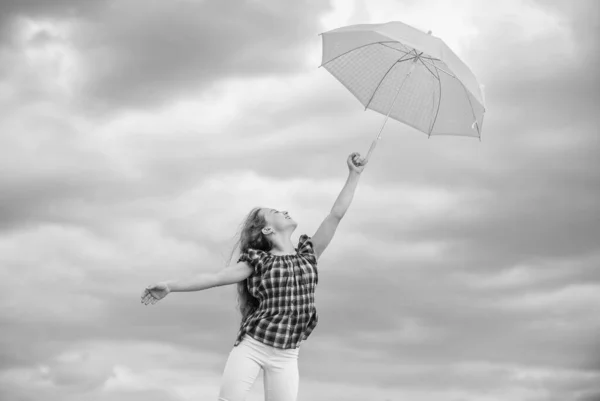 Kind fliegen im bewölkten Himmel. Regenschutz. glückliches kleines Mädchen mit Regenschirm. positive Stimmung bei jedem Wetter. Schulzeit. Herbstzeit. Regenwetter vorhergesagt. Herbst-Kindermode. Tagessieger — Stockfoto