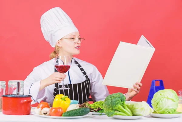 Culinary expert. Chef cooking healthy food. Girl read book best culinary recipes. Culinary school concept. Book by famous chef copy space. Professional level. Woman hat and apron study culinary arts