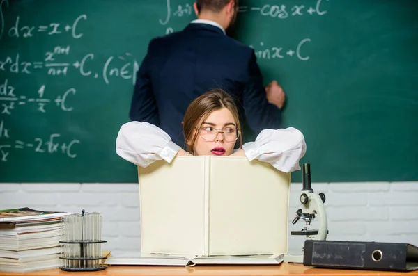 Pensando mucho. Bonita profesora dando tarea. Estudiante escribiendo tareas en pizarra. Haciendo los deberes juntos. Asignación y tarea de tareas. Escuela y educación. Enseñanza y aprendizaje — Foto de Stock