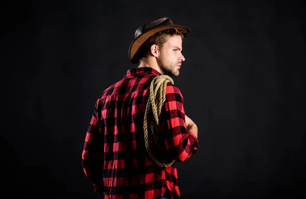 Campagna. Uomo in stile vintage. Un cowboy retrò del Wild West. cowboy con corda di lazo. Occidentale. Camicia a scacchi da uomo al ranch. ritratto del cowboy occidentale. Wild West Rodeo. uomo in cappello fondo nero — Foto Stock