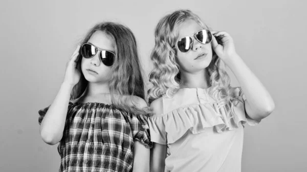 Προστασία UV. Υγεία των ματιών. Αγοράστε τα κατάλληλα γυαλιά ηλίου. Κατάστημα οπτικών. Χαριτωμένα μικρά παιδιά μόδας κορίτσια. Κορίτσια μακριά σγουρά μαλλιά φορούν γυαλιά ηλίου. Γυαλιά ηλίου καλοκαιρινό αξεσουάρ. Καλοκαιρινή τάση. Μικρή μόδα — Φωτογραφία Αρχείου