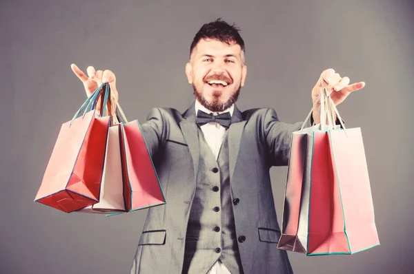 Uomo d'affari col papillon. borse pesanti. Shopholic maturo. esteta elegante con borse della spesa. acquisto vacanze. Affari. Grande vendita. uomo barbuto in giacca e cravatta. risparmi sugli acquisti. godendo di shopping online — Foto Stock