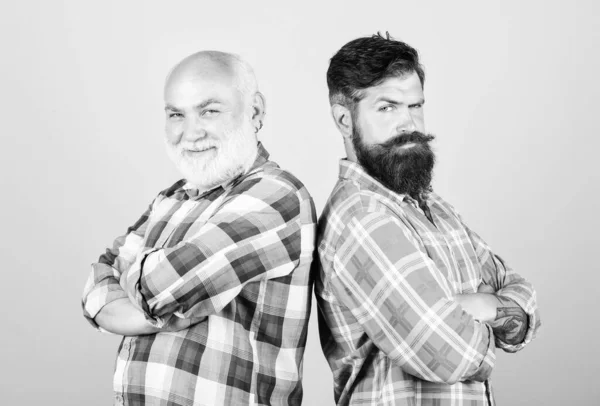 Brutal guys with long beard. Barber well groomed handsome bearded man. Father and son. Hairdresser salon. Barbershop concept. Men bearded hipster stand back to back. Bearded friends. Family team
