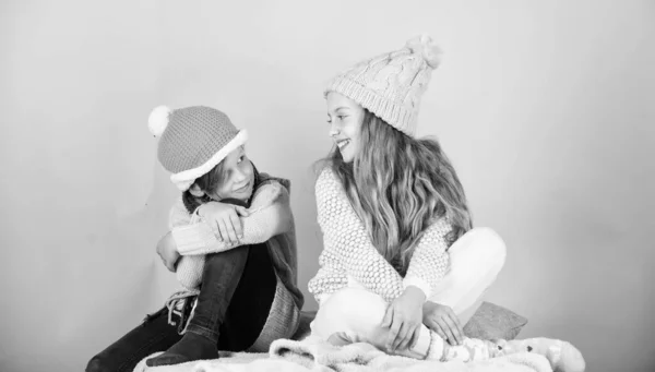 Calienta tu ropa de invierno con accesorios lindos y acogedores. Los hermanos usan sombreros cálidos de invierno sobre fondo rosa. Niños y niñas se calientan con suéteres y sombreros. Manténgase caliente y cómodo — Foto de Stock