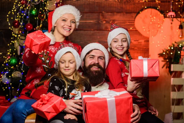 gift can do everything. open xmas present. gifts from santa. small girls sisters with parents. father at decorated tree. cheerful mother love children. Happy family celebrate new year and Christmas