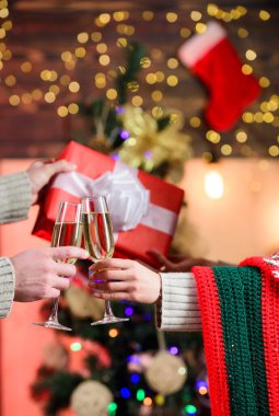 Noel tatili için hediye. Sevgiyle hediye. Erkek kadına kutu verir. Aile değerleri. Birbirine aşık çiftlerin elleri. Mutlu noeller. Mutlu yıllar. Hafta sonu kış tatili. Bir bardak şampanya. seçici odak