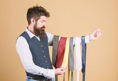 Elbise ve gömlek yanı sıra bir aksan sağlamak için en az bir renk renkleri vardır kravat seçin. Adam sakallı hipster birkaç kravat tutun. Sakallı adam, kravat seçiyor. Mükemmel kravat