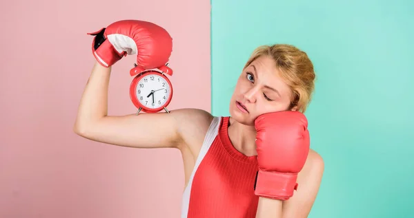 Control time. Time management skills. Battle for self discipline. Woman holding clock boxing gloves. Boxer fighting with alarm clock. Time for boxing training. Punctuality and personal efficiency