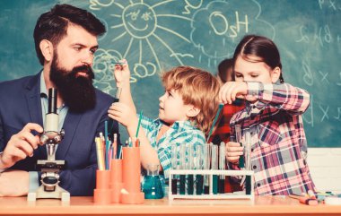 Büyük çocuklar daha genç yardım. Okul kulübü eğitimi. Öğretmen ve öğrenciler sınıfta test tüpleri. Kimya temalı kulüp. Maddelerin özelliklerini birlikte keşfedin ve keşfedin. İlgi alanları ve konu kulübü