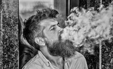 Elektronik sigara içiyor. Stres giderme konsepti. Sigara içme cihazı. Adam uzun sakal sigara alışkanlığı ile rahat. Aromalı duman bulutları. Sakallı adam vape içiyor. Sakallı adam duman solumak
