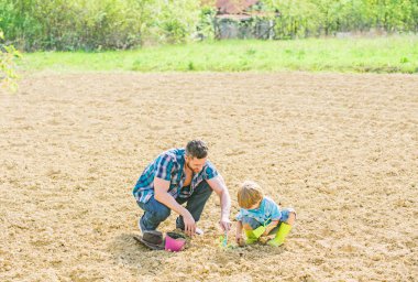 küçük çocuk çocuk tarım baba yardım. yeni bir hayat. toprak ve gübre. baba ve oğul toprağa çiçek ekiyor. mutlu dünya günü. Aile ağacı. zengin doğal toprak. Eko çiftlik. dünya günü. Başarılı olun