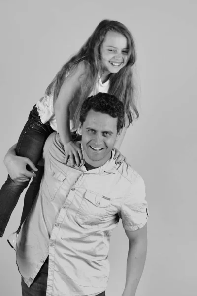 Daughter and father hug each other. Schoolgirl on dads shoulders.