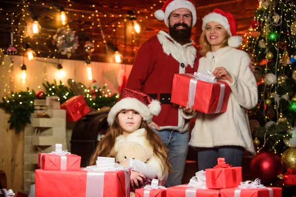 Las tradiciones navideñas. Caridad y bondad. Para hacer el bien. Sentirse amado. Recuerdos de Navidad. Momentos felices. Una chica en casa en Nochebuena. Adopción de niños. El chiquitín celebran un nuevo año con la pila de los regalos — Foto de Stock