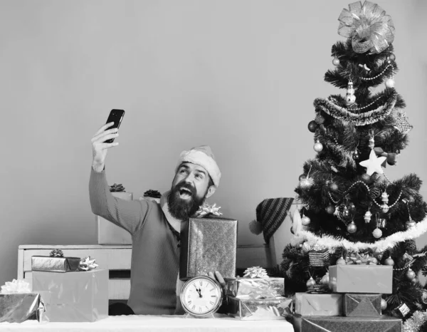 Noel Baba 'nın elinde cep telefonu ve hediye kutusu var. Sakallı adam — Stok fotoğraf