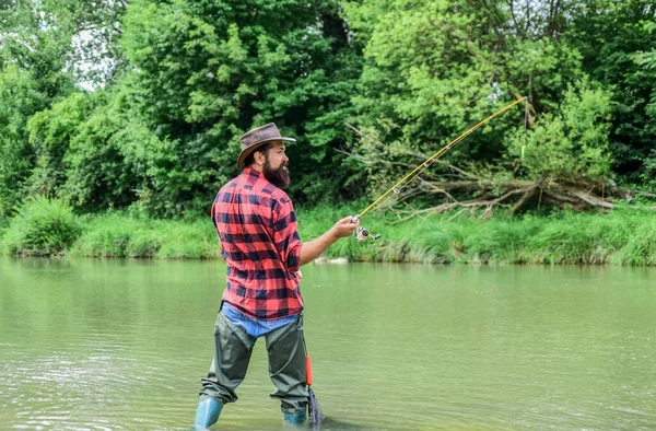 Keep Calm and Fish On. mature man fly fishing. man catching fish. fisherman with fishing rod. hobby and sport activity. pothunter. bearded fisher in water. summer weekend. Big game fishing