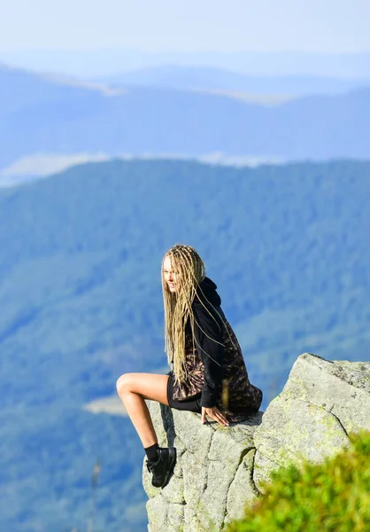На краю света. Женщина сидит на краю скалы на фоне высоких гор. Пеший спокойный момент. Наслаждайся видом. Туристка, отдыхающая на краю утёса. Опасный отдых. Экстремальная концепция — стоковое фото