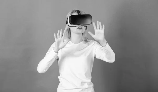 Vicces fiatal nő VR-rel. Gyönyörű nő, virtuális valóság szemüveget visel a stúdióban. A nő VR-t használ. Technológia VR. — Stock Fotó