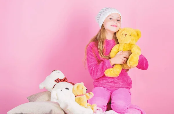 Unique attachments to stuffed animals. Child small girl playful hold teddy bear plush toy. Teddy bears improve psychological wellbeing. Kid little girl play with soft toy teddy bear pink background