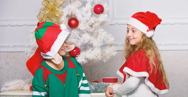 孩子们穿着圣诞老人和精灵的服装。冬季化装舞会的概念。圣诞快乐。家庭度假传统。孩子们欢庆圣诞节。兄弟姐妹们准备庆祝圣诞节或迎接新年 — 图库照片