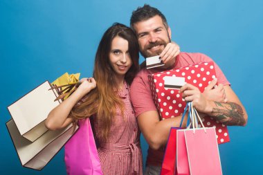 Yüz gülümseyen sakallı adam pembe paketleri tutar.