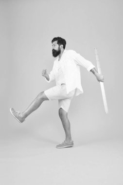 Acımasız dünyada bilgi. Acımasız hipster sarı arka plan üzerinde cetvel ile yürüyüş. Acımasız bakışlı sakallı adam okula gidiyor. Acımasız kafkas adam okula geri ve serin görünümlü