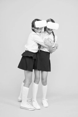VR teknolojileri. Mutlu çocuklar modern teknolojiyi kullanır. Çocuklar kablosuz sanal gerçeklik gözlüğü takıyor. Sanal gerçeklik. VR kulaklıklı küçük kızlar. Gelecekteki eğitim. Okula dönüyorum. Dijital gelecek ve yenilik