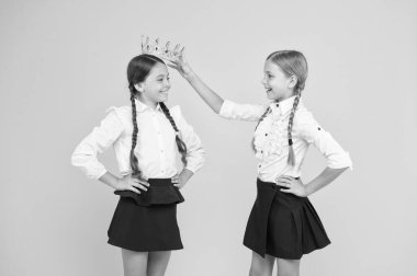 Taç ona yakışıyor. Sevimli küçük bir çocuk, küçük şampiyon kızı tacıyla ödüllendiriyor. Mutlu küçük kazananlar ve şampiyon taç giyme töreni. Şampiyon tacını taktı. Okul yarışmaları konsepti. Kraliyet dostluğu