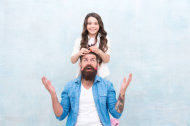 Senin kadar bireysel. Küçük kız hippi grisi arka planda saç yapıyor. Küçük çocuk ve hippi tarzı sakallı bir adam. Sevimli kızı ve hippi babası. Berber dükkanı. Kendin ol, hipster ol.