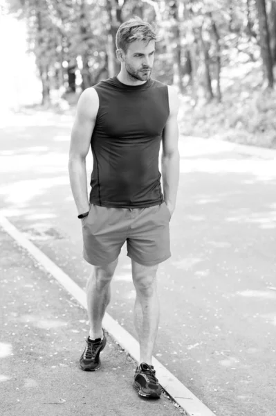 Es bastante deportivo. Hombre atlético caminando sobre el paisaje natural. Hombre guapo con el pelo de la cara sin afeitar y corte de pelo elegante entrenamiento al aire libre. Caucásico hombre en ropa deportiva en el día de verano — Foto de Stock