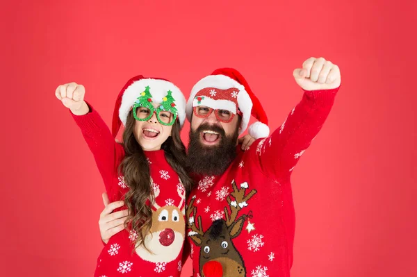 Holiday atmosphere. winter holiday with family. happy father and daughter love xmas. small girl and dad santa hat. daddy and kid red background. christmas time. new year party. happy to be together