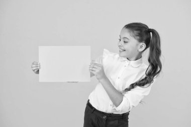 Muhteşem renk. Küçük kız sarı arka plan üzerinde boş bir kağıt kağıdı tutuyor. Atama veya proje çalışması için boş yeşil okul kağıdı olan küçük çocuk. Sınav kağıdı. Kopya kağıdı, kopyalama alanı