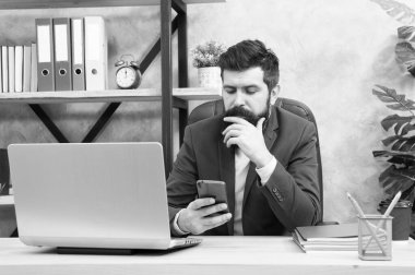 Ortağını ara. Sakallı patron, ofiste dizüstü bilgisayarla oturuyor. Yönetici sorunları çözüyor. Görevli işadamı başarılı iş çözümleri sunuyor. İş stratejisi geliştiriyorum. Riskli iş