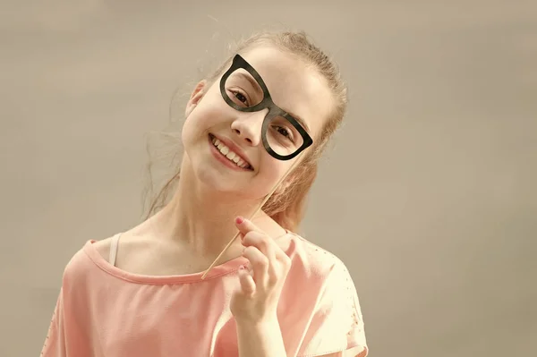 그녀는 행복을 발산하고 있습니다. 소품 안경을 통해 재미있는 표정으로 작은 웃는 소녀. 행복과 빛나는 사랑스러운 얼굴과 행복한 작은 아이. 아이들은 많은 행복을 가져다줍니다. 행복 컨셉 — 스톡 사진