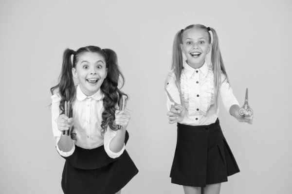 Возвращение в школу 1 сентября. Счастливые маленькие дети, держа в руках маркер и ножницы 1 сентября. Маленькие ученики, имеющие искусство и ремесла 1 сентября. Слушать и учиться на 1 сентября
