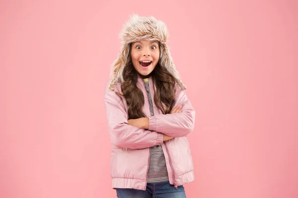 부드러운 모피 액세서리. 어린이의 긴 털 이연 한 털 모자는 부드럽기를 좋아한다. 겨울 패션 컨셉. 추운 날씨를 위한 따뜻 한 모자. 가짜 모피 유행이야. 길고 곱슬머리 소녀는 털 모자를 쓰고 있고 귀는 분홍빛 배경을 가지고 있다 — 스톡 사진